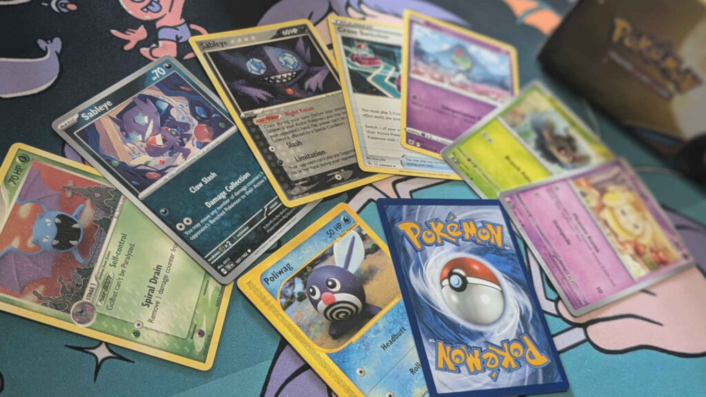 A selection of old and new Pokemon cards laid out on a playmat