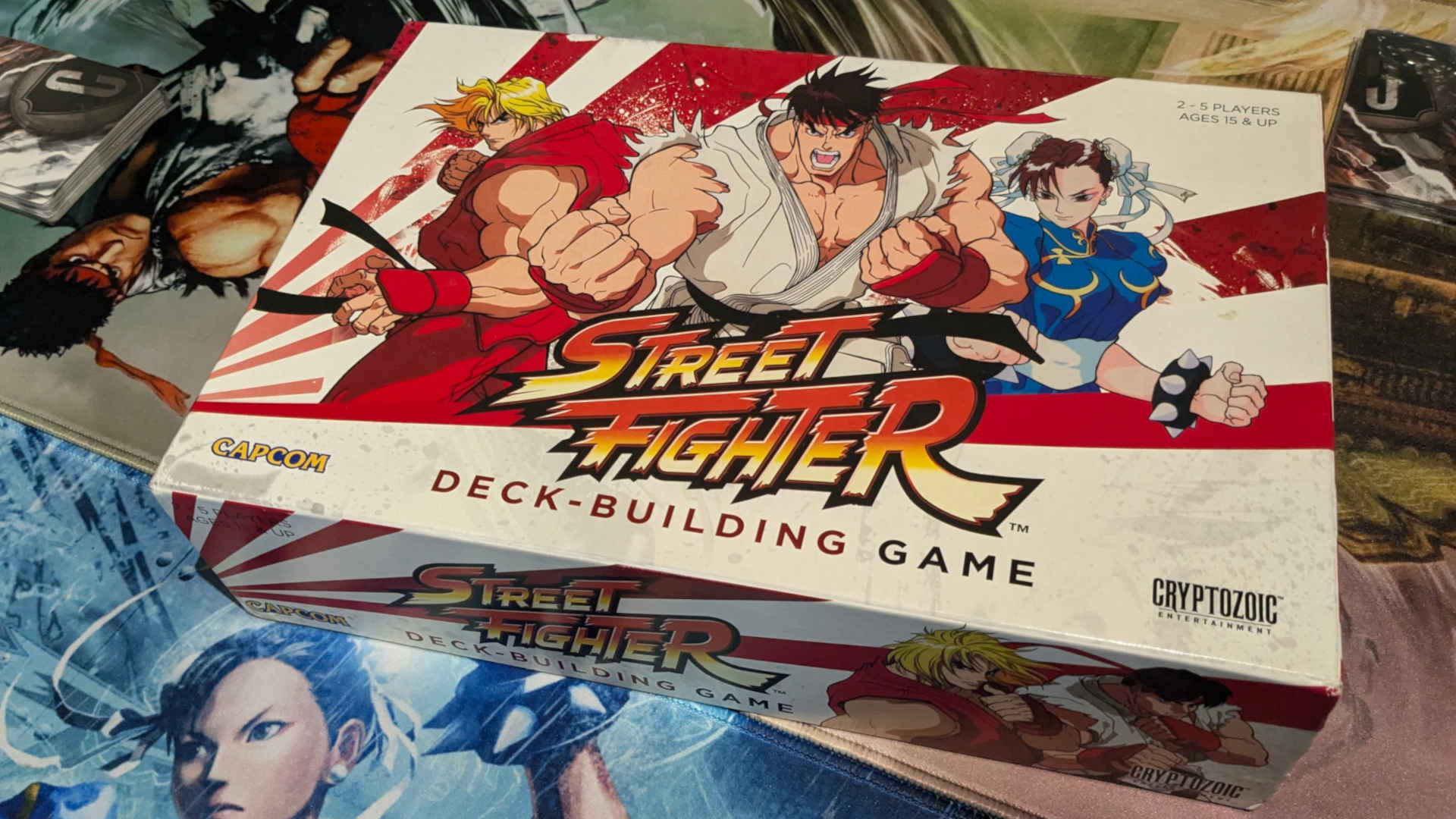 Street Fighter Deck Building Game Box on two play mats