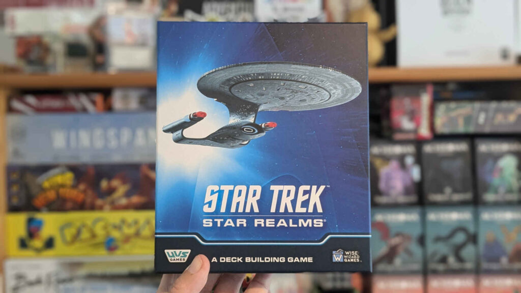 A hand holding the Star Trek Star Realms game box