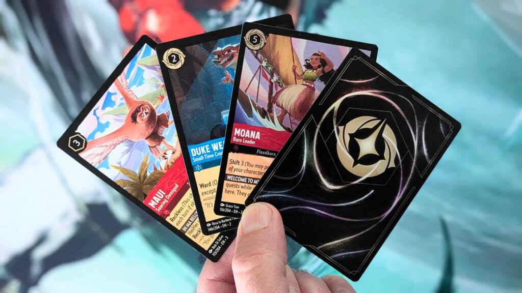 Disney Lorcana cards fanned out in hand, with set codes visible